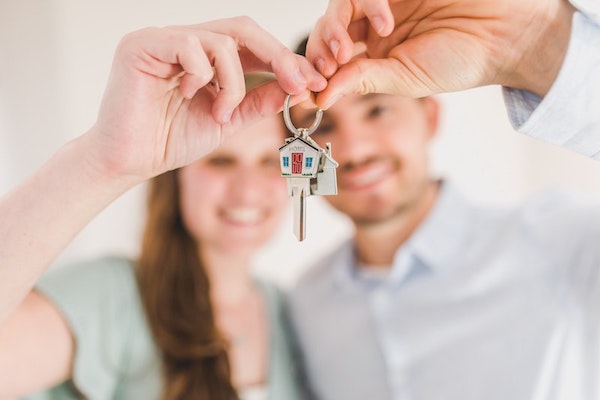 Man and Woman Holding Up Keys to Home